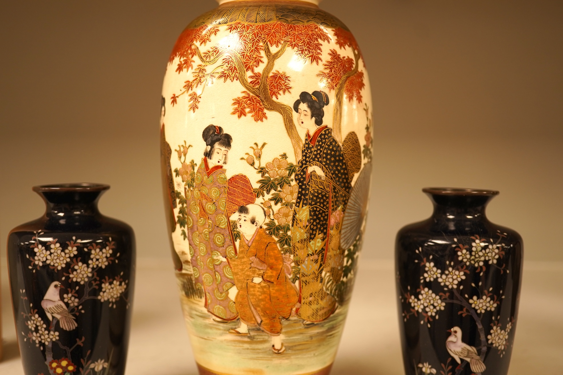 A Japanese figural satsuma vase and a pair of small black cloisonné enamel vases, Satsuma 21.5cm high